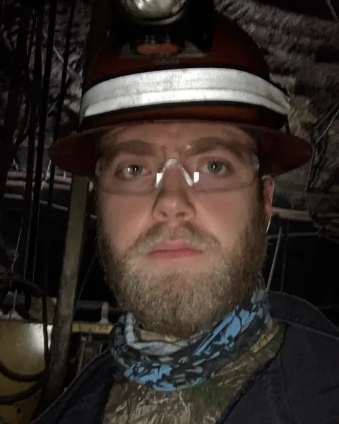 Dan Gauerke underground in a hard hat, cap lamp and safety glasses
