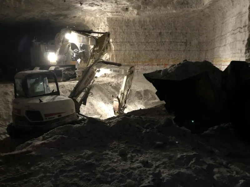 An excavator under lights in a salt mine
